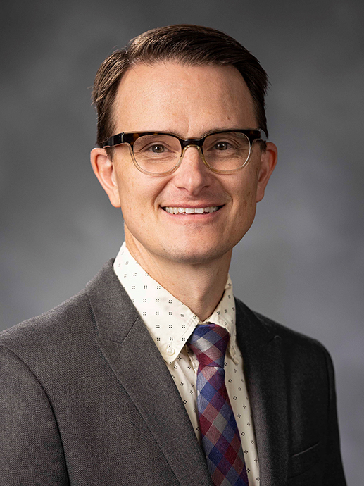 A man with glasses, suit and tie.